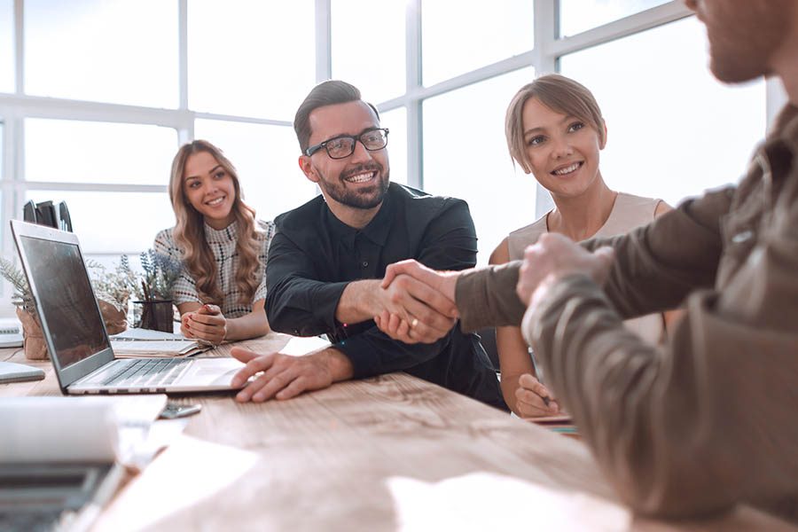 Who We Are - Twin City Group Insurance Agency Team Shaking Hands at a Business Meeting in the Office